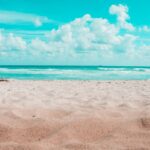 beach under blue sky and white clouds during daytime