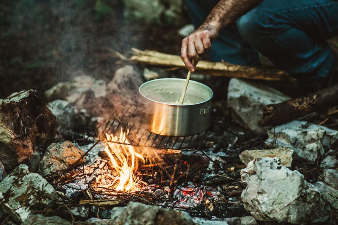 person cooking on bonefire