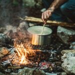 person cooking on bonefire