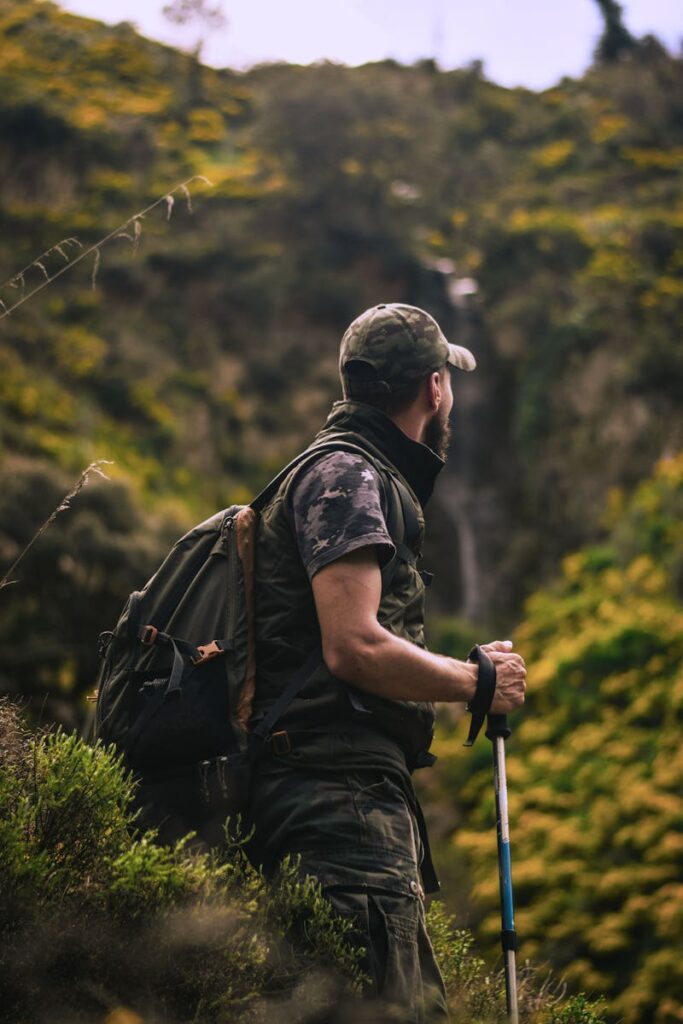 Man Wearing Cap and Crew-neck Shirt Standing in the Middle of Forest