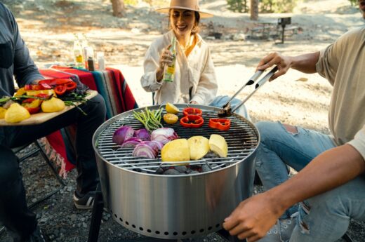 a man and a woman cooking food on a grill