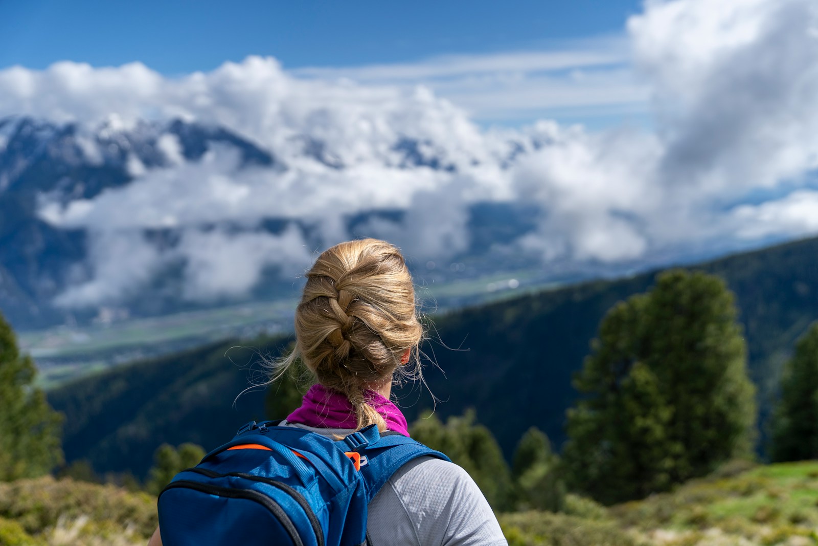 A woman with a backpack looking at the mountains